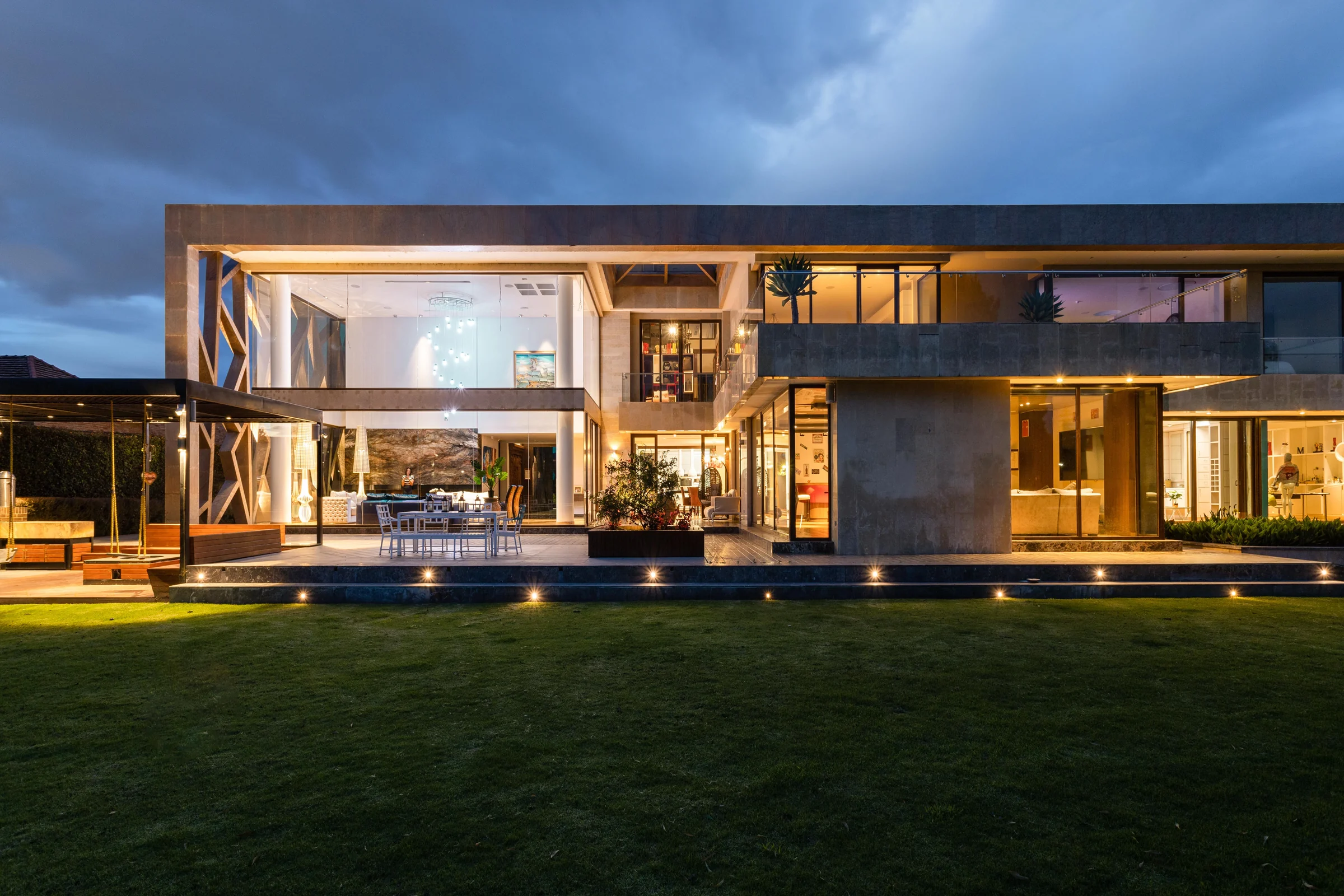 Concrete and glass villa lit from inside at dusk